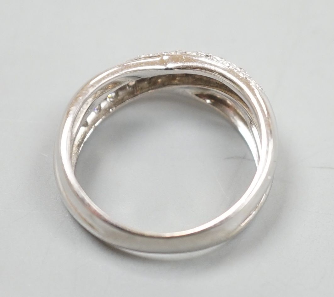 A modern 750 white metal and pave set set diamond crossover ring, size L/M, gross weight 5.9 grams.